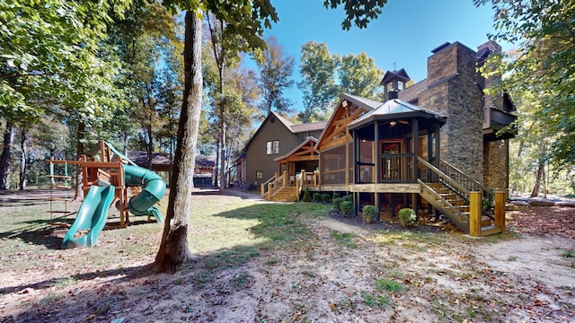 back of property featuring a playground