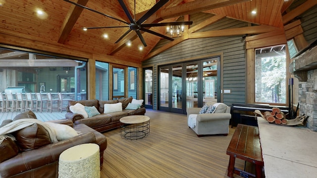 sunroom with a stone fireplace, lofted ceiling with beams, ceiling fan, and wooden ceiling