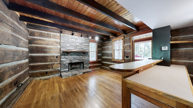 interior space featuring a fireplace, beam ceiling, hardwood / wood-style floors, rail lighting, and wooden ceiling