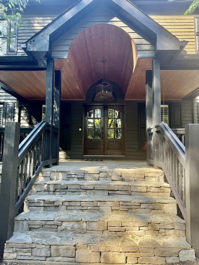 view of exterior entry with french doors and a porch