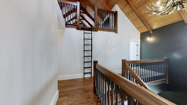 stairs featuring wood-type flooring, a notable chandelier, wooden ceiling, high vaulted ceiling, and beamed ceiling