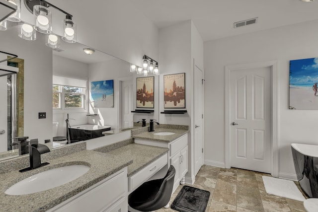 bathroom with a bathtub, vanity, and an inviting chandelier