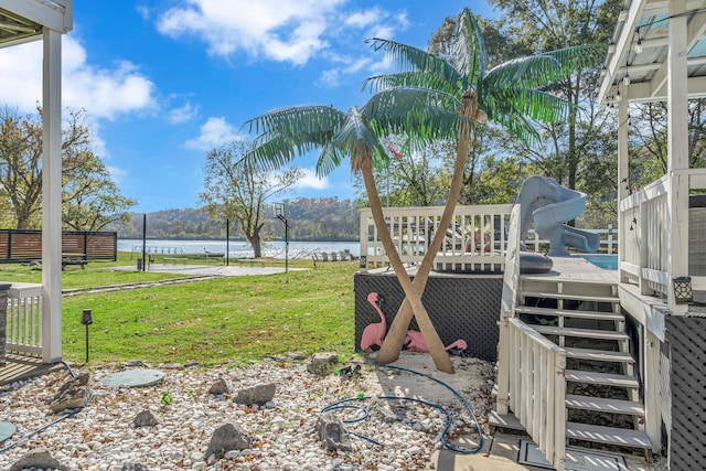 view of yard with a deck with water view