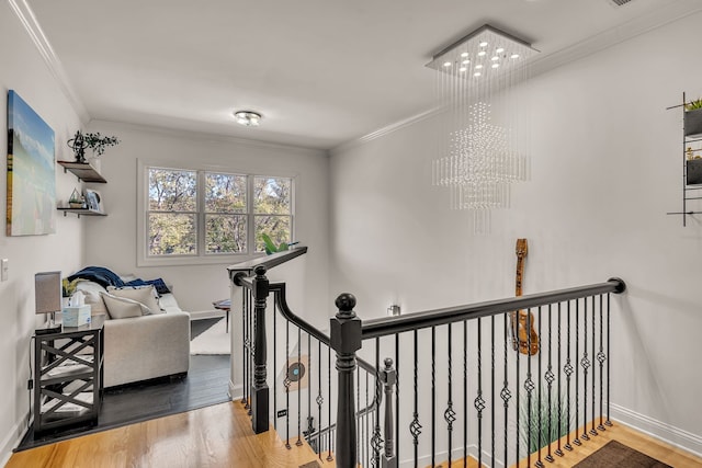 hallway featuring ornamental molding, hardwood / wood-style flooring, and a chandelier