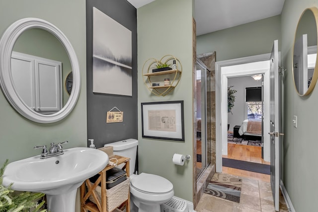 bathroom with hardwood / wood-style flooring, a shower with shower door, sink, and toilet