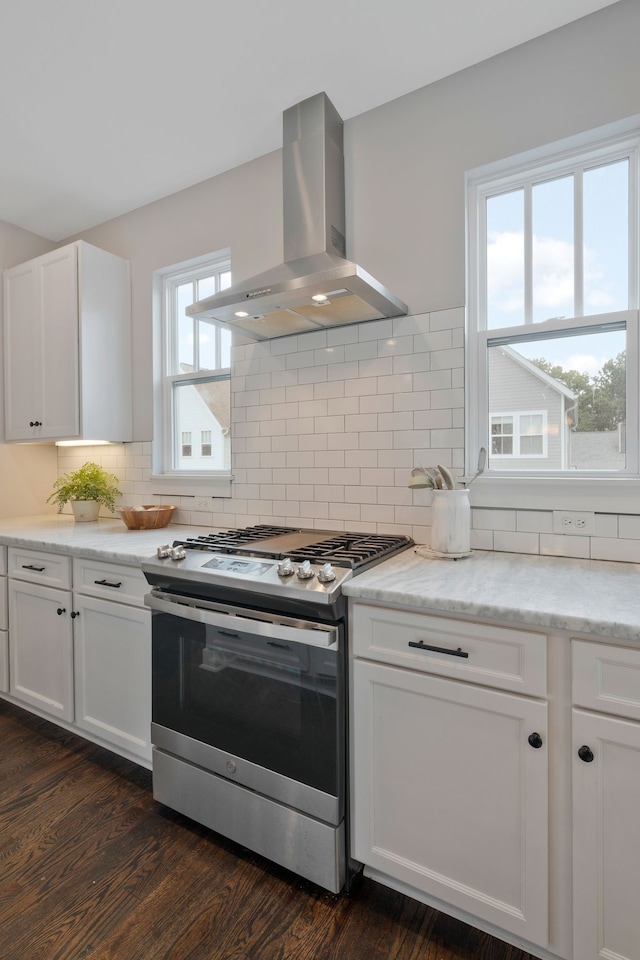 kitchen featuring white cabinets, dark hardwood / wood-style flooring, decorative backsplash, gas stove, and wall chimney range hood