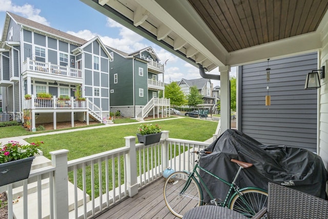 wooden deck featuring a grill and a lawn