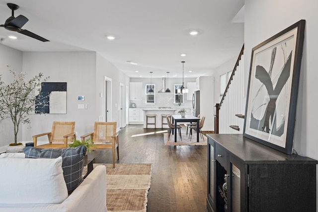 living room with ceiling fan and dark hardwood / wood-style flooring