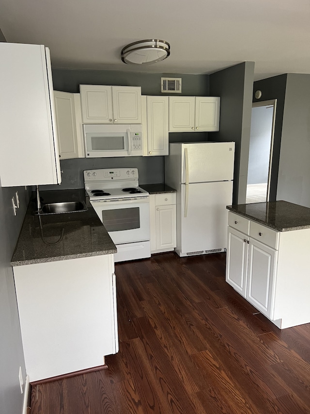 kitchen featuring dark hardwood / wood-style flooring, white cabinets, sink, white appliances, and dark stone countertops