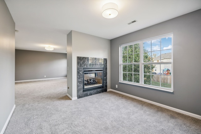 unfurnished living room with a multi sided fireplace and carpet