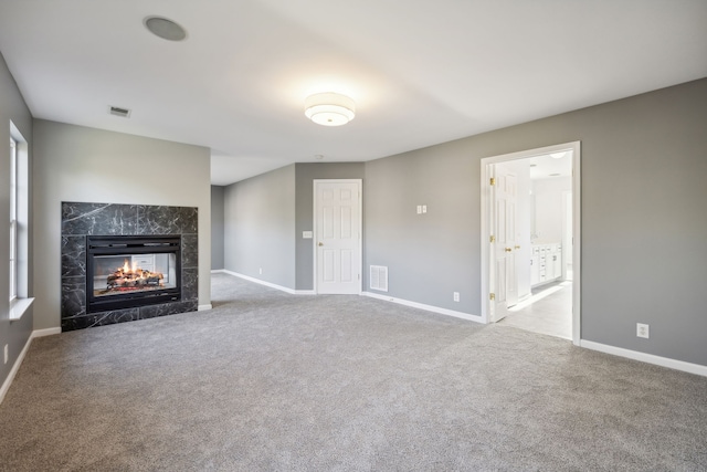 unfurnished living room featuring carpet flooring and a multi sided fireplace