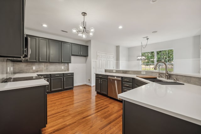 kitchen featuring sink, an inviting chandelier, hardwood / wood-style floors, hanging light fixtures, and dishwasher