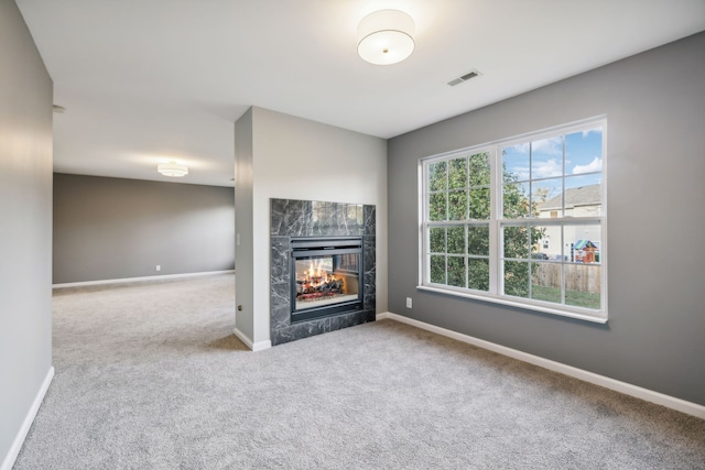 unfurnished living room featuring a multi sided fireplace and carpet