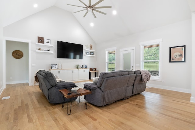 living room featuring ceiling fan, light hardwood / wood-style flooring, and high vaulted ceiling