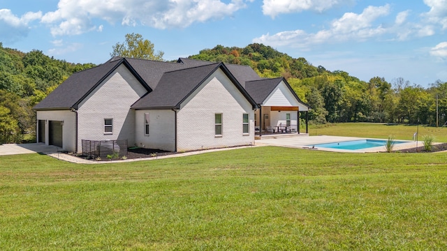 back of house with a patio and a lawn