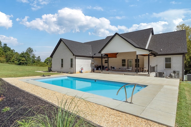 view of pool featuring central air condition unit, a lawn, and a patio area