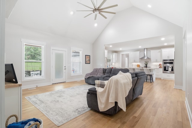 living room featuring high vaulted ceiling, light wood-type flooring, and ceiling fan