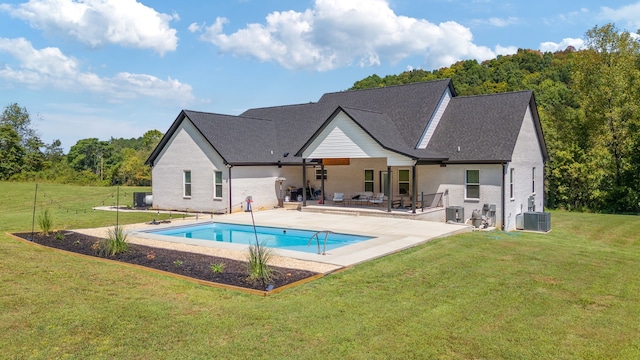 rear view of property featuring a patio, a lawn, and cooling unit