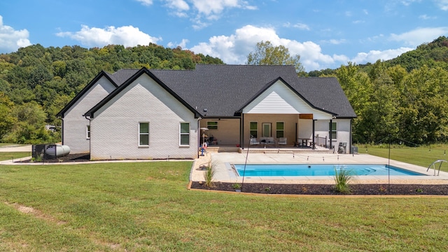 back of house with a lawn and a patio area