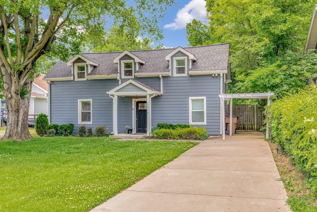 view of front of property featuring a shingled roof, a front yard, and fence