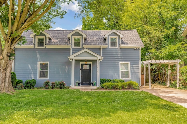 view of front of house with a shingled roof, a front yard, and a pergola