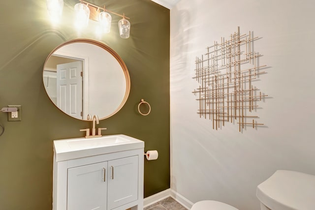 bathroom featuring baseboards, vanity, and toilet