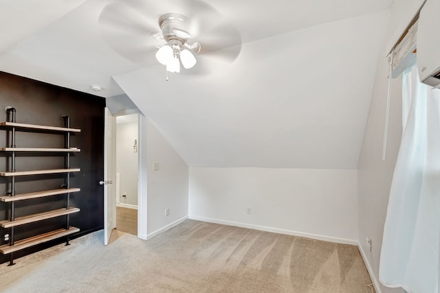 additional living space featuring light carpet, ceiling fan, baseboards, and lofted ceiling