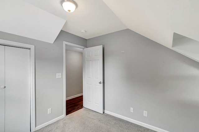 additional living space featuring carpet, baseboards, and vaulted ceiling