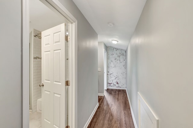 corridor featuring baseboards and wood finished floors