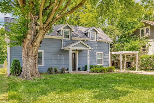 cape cod house featuring a shingled roof, a front lawn, and a pergola