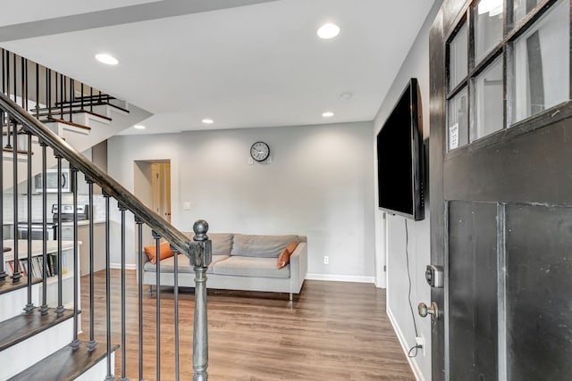 foyer with baseboards, wood finished floors, stairs, and recessed lighting