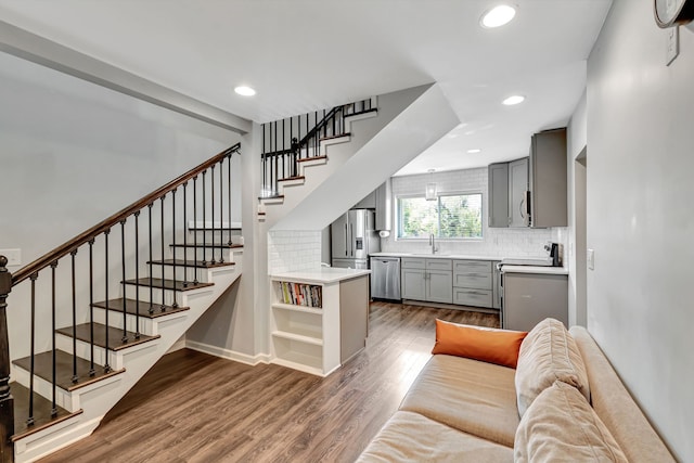 living area featuring stairs, dark wood finished floors, and recessed lighting