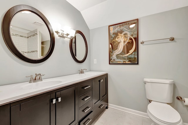 bathroom featuring vaulted ceiling, a sink, toilet, and baseboards