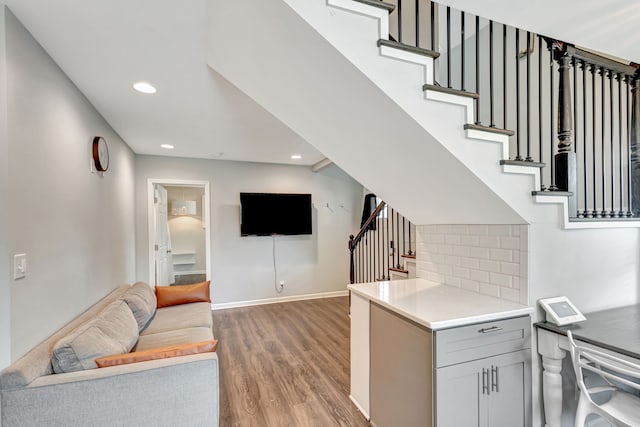 living room with stairs, baseboards, wood finished floors, and recessed lighting