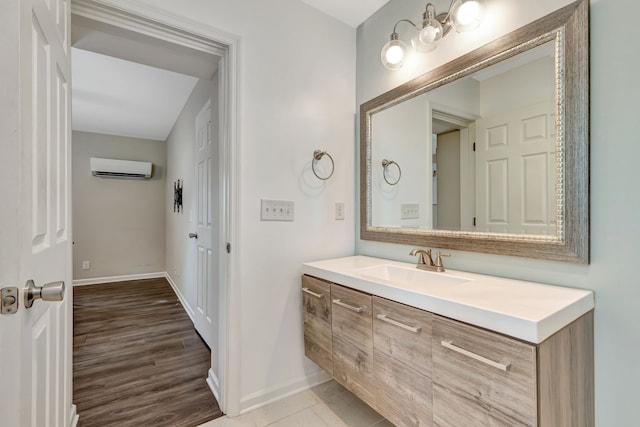 bathroom featuring an AC wall unit, wood finished floors, vanity, and baseboards