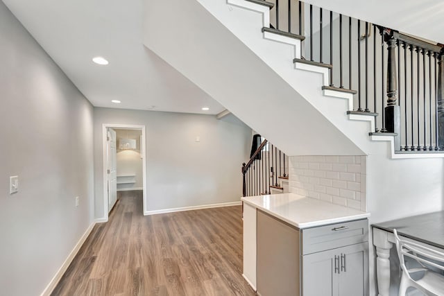 interior space with baseboards, wood finished floors, and recessed lighting