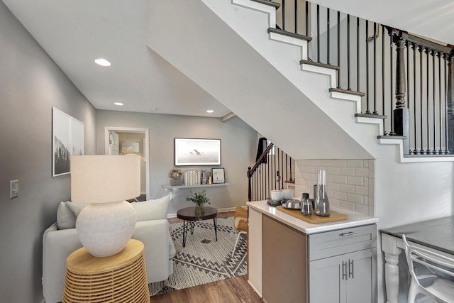 interior space featuring decorative backsplash, wood finished floors, light countertops, gray cabinetry, and recessed lighting