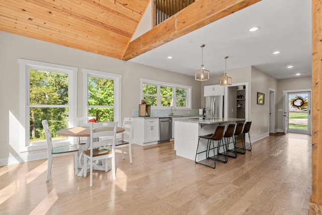 kitchen featuring a center island, stainless steel appliances, light stone counters, and a wealth of natural light