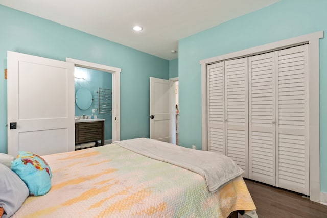 bedroom featuring a closet, ensuite bathroom, and dark hardwood / wood-style flooring