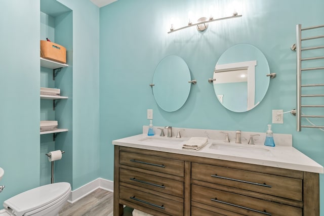 bathroom featuring toilet, vanity, and hardwood / wood-style flooring