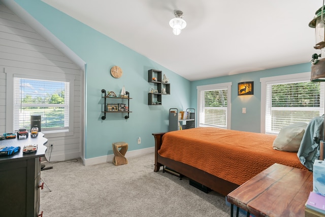 bedroom featuring wood walls, light colored carpet, and lofted ceiling