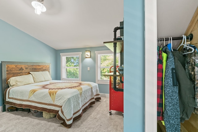 bedroom with light colored carpet and lofted ceiling