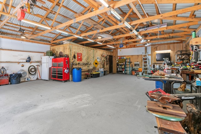 garage with a workshop area and white fridge