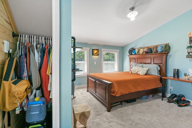 bedroom featuring light colored carpet and lofted ceiling