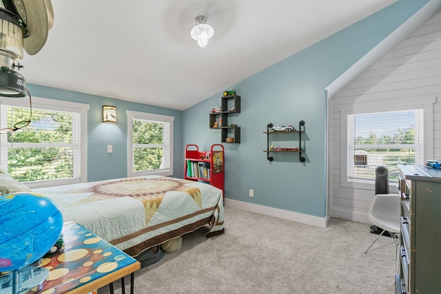 bedroom featuring wooden walls, light colored carpet, and lofted ceiling