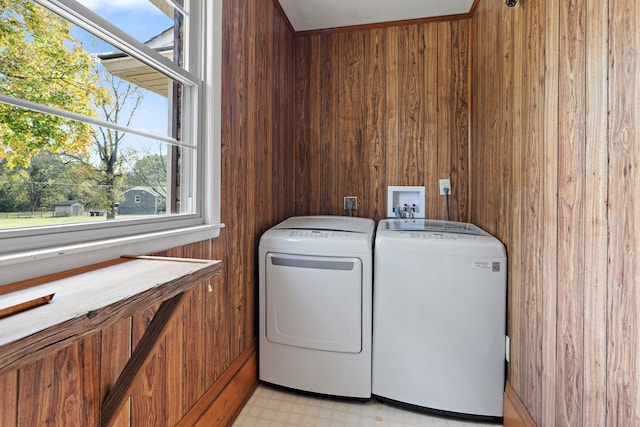 washroom with wood walls and washer and dryer