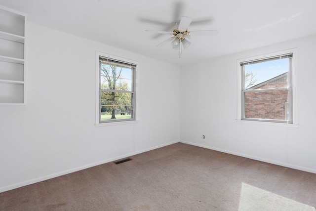 carpeted spare room with ceiling fan