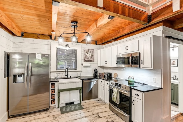 kitchen with sink, tasteful backsplash, white cabinetry, appliances with stainless steel finishes, and decorative light fixtures