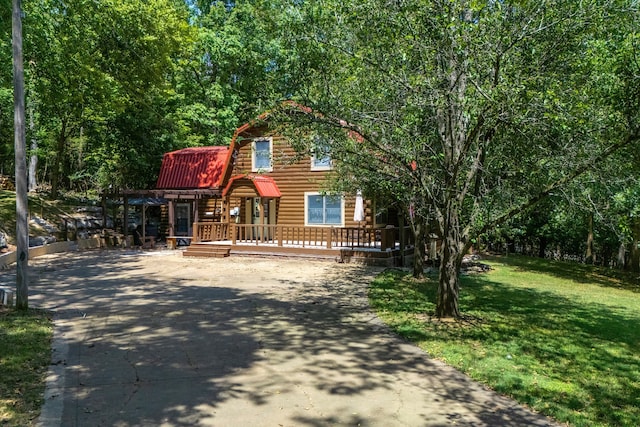 log home with a wooden deck and a front yard