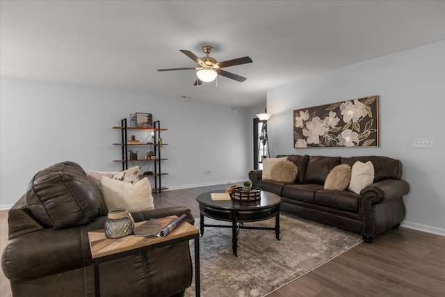 living room featuring dark wood-type flooring and ceiling fan